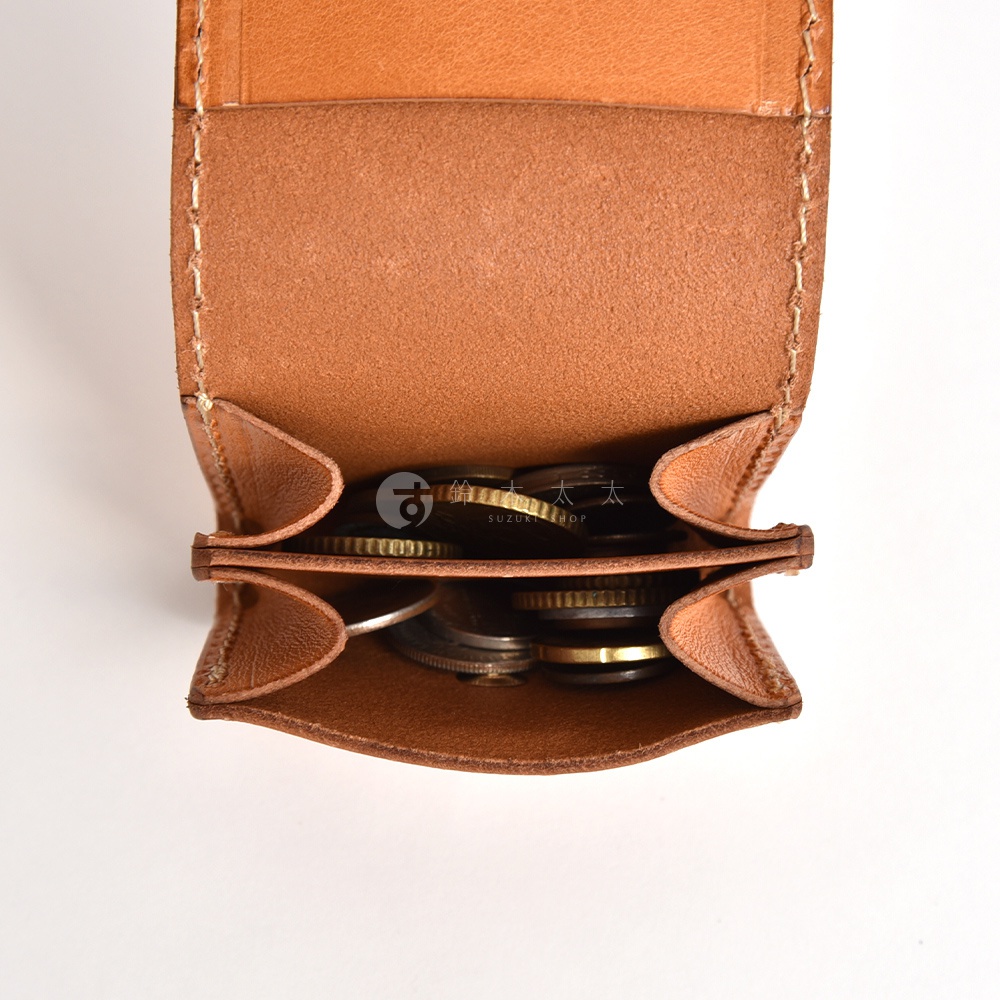一個由日本HERZ職人手作的棕色皮革零錢包，採取上方開口設計並設有兩個夾層，內部放置著各式硬幣，整體呈現出皮革質感與精緻縫線細節。