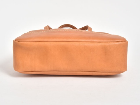 一個淺棕色皮革製成的直式托特包，側面展示其厚實的底部和縫線細節。