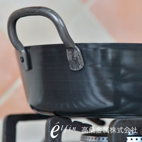 日製雙耳鍛鐵炸鍋，鍋身為黑色鍛鐵材質，帶有兩個彎曲的鍛鐵提把，提把以鉚釘固定在鍋緣。