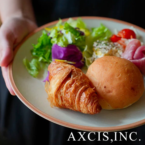 PURE 素燒百搭陶瓷主菜盤，盤中盛有可頌麵包、餐包、沙拉、火腿及小番茄，盤緣為淺粉色，盤面為米白色陶瓷。