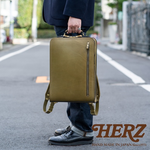 職人手作皮革商務電腦後背包 R-25，橄欖綠色，簡約方形設計，正面有拉鍊口袋，採用高品質皮革，展現精緻工藝。