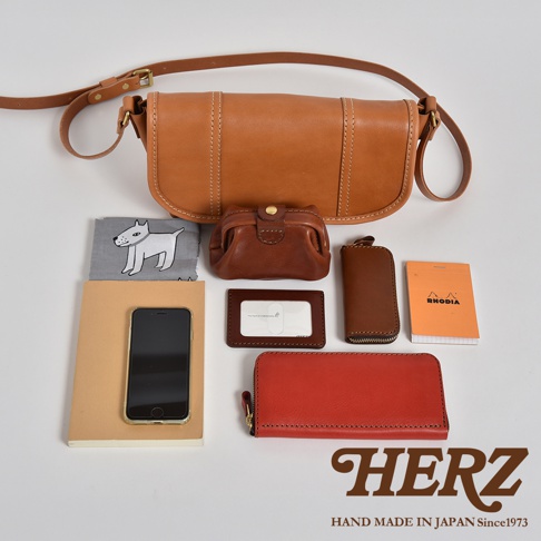 職人手作皮革復古郵差包，咖啡色皮革，附長夾、零錢包、鑰匙包、卡夾、筆記本與手機，樣式簡約大方。