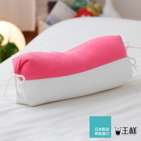 一個粉紅色與白色相間的糖果形狀長枕，材質柔軟，兩端有白色綁繩。