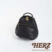 職人手作皮革輕旅行後背包 R-144，黑色。採用柔軟皮革，圓潤包型，設有金屬旋轉鎖扣與拉鍊口袋，搭配金色五金配件，設計簡約實用。