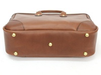 棕色皮革托特包，設有頂部提把、金色金屬釘飾和縫線細節。