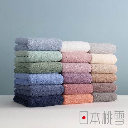 日本桃雪精梳棉飯店浴巾，堆疊成三列的多彩純棉毛巾，由左至右分別為藍色系、紅色與粉色系、以及灰色與大地色系，整體呈現柔和的棉質質感，下方標示著日本桃雪品牌名稱。