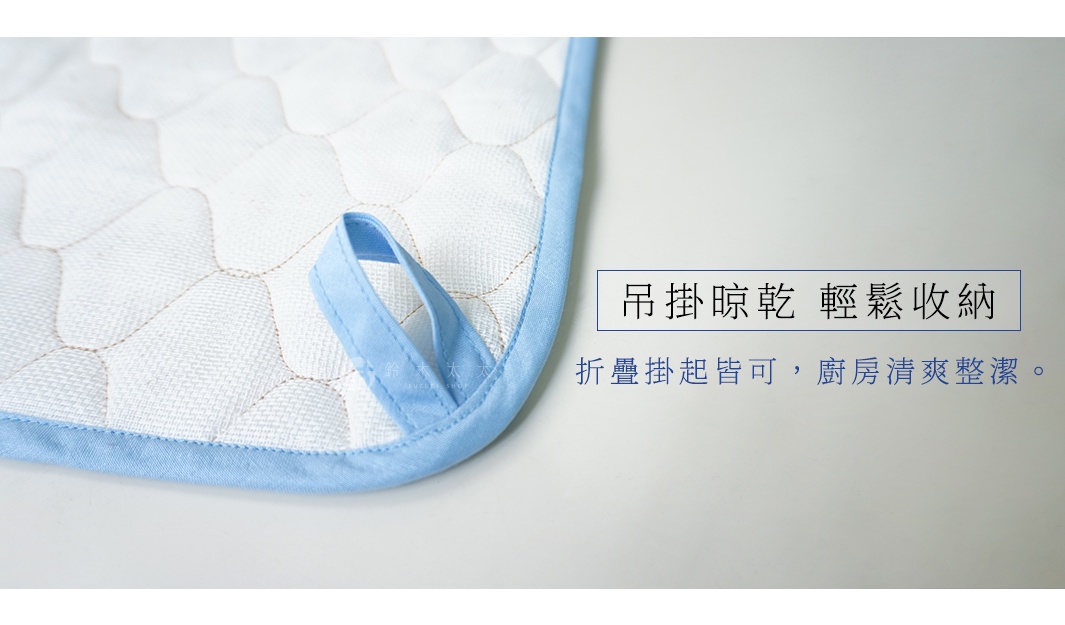 淺藍色滾邊的白色棉織吸水墊，表面有菱形格紋縫線，角落帶有淺藍色掛繩。