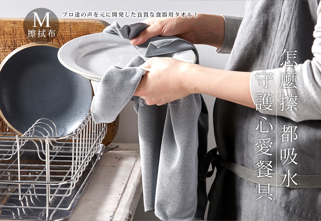 灰色超細纖維碗盤擦拭布，布面有細緻條紋，柔軟吸水，正用於擦拭白色盤子。