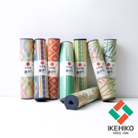 七款捲起的藺草榻榻米瑜珈墊，皆有不同的日式幾何圖案，包含紅、綠、藍、黃等配色。其中一款攤開平放，露出底部藍灰色止滑層。