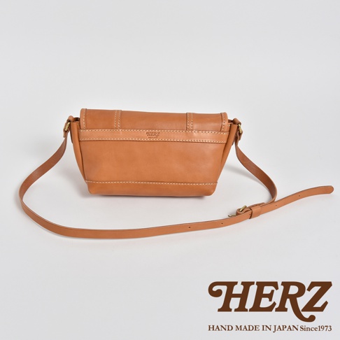 職人手作皮革復古郵差包，採用棕褐色皮革製成，包身線條簡約，車縫線清晰，配有可調整長度的皮革背帶。