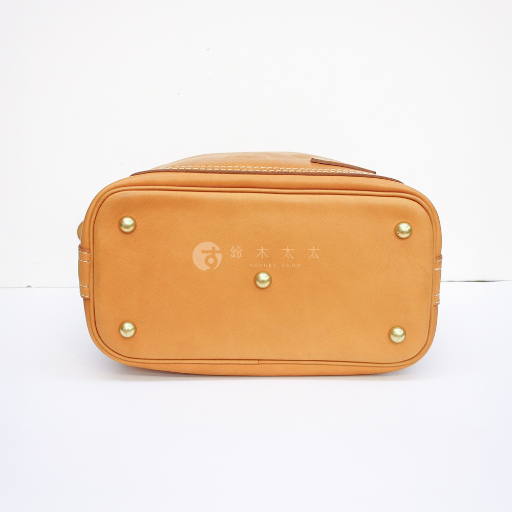 職人手作皮革厚實單肩波士頓包，底部為棕褐色皮革，設有四個金屬腳釘，中央印有品牌標誌。