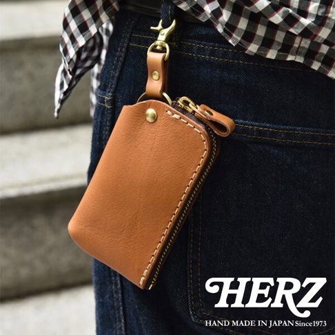 職人手作皮革鑰匙包，採用天然牛皮製成，經典棕色，配有黃銅五金配件及拉鍊，適合懸掛於腰間。