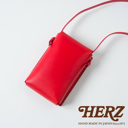 職人手作皮革手機包 CP-11，採用鮮紅色皮革製作，設計簡約，帶有細緻的手縫線條與綁帶細節，適合搭配各式風格。