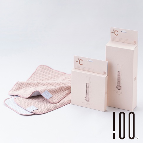 兩條粉紅色系的格紋涼感毛巾，其中一條疊在另一條上方，帶有品牌的圓形標誌。旁邊是兩個粉紅色紙盒包裝，盒面上印有溫度計圖案和品牌標誌。