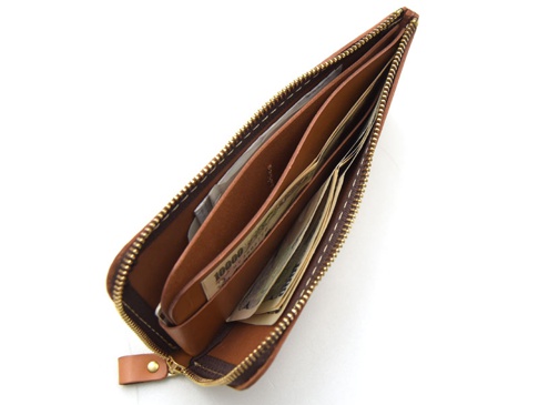 職人手作皮革L型拉鍊長夾，溫潤的棕色皮革，內部有多個隔層，裝有日圓鈔票，拉鍊為金色，搭配皮革拉頭。