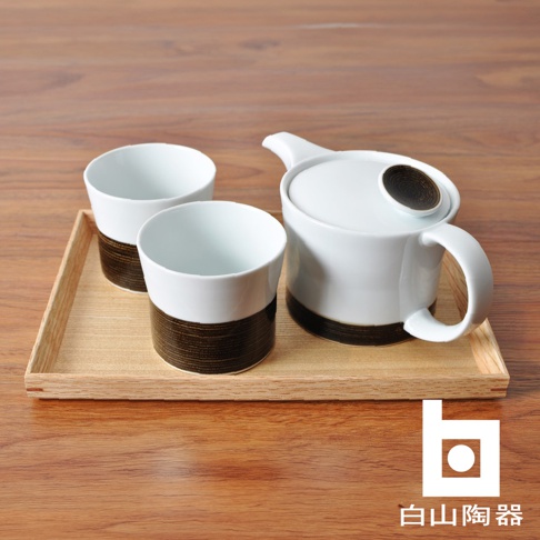 白色陶瓷茶壺與三個搭配咖啡色麻紋的杯子，擺放在淺木色托盤上。