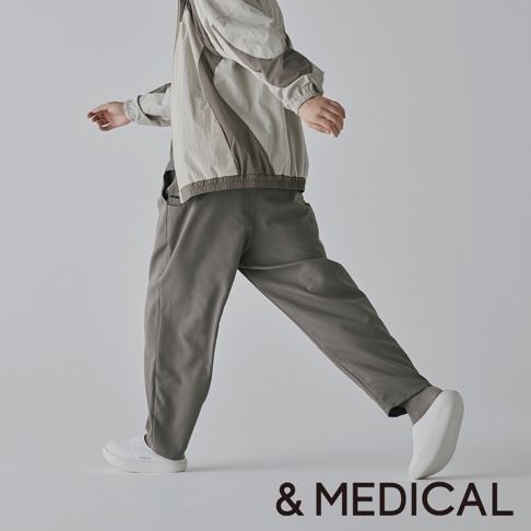 一位身穿&MEDICAL品牌運動服飾的人，以動態姿態展示服飾。