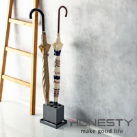 深灰色珪藻土六孔傘架，內有兩把傘，一把為卡其色，另一把為米白、粉條紋與深藍條紋交錯的傘，傘架旁為木製梯子。