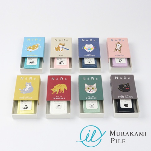 這張圖片展示了八款村上棉 NaRe 系列刺繡犬貓壓縮小方巾。上方四款為狗狗圖案，下方四款為貓咪圖案，每款方巾均以長方形紙盒包裝，盒面上繪有可愛的寵物插畫並標示出動作名稱。這些色彩繽紛的壓縮方巾整齊排列在白色背景上，右下方則印有 Murakami Pile 的品牌標誌。