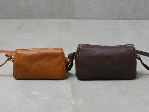 兩款職人手作皮革Organ輕巧拉鍊單肩包，一款為淺棕色，另一款為深棕色，皆為拉鍊式開合，搭配金屬拉鍊及肩帶扣環。