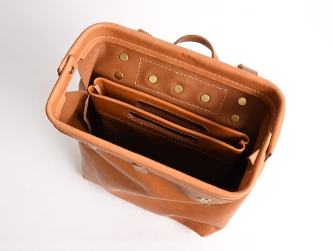 職人手作皮革直式收納袋中袋 (S-3-T)，淺棕色皮革材質，內含兩個隔層，袋口邊緣有銅質鉚釘裝飾。