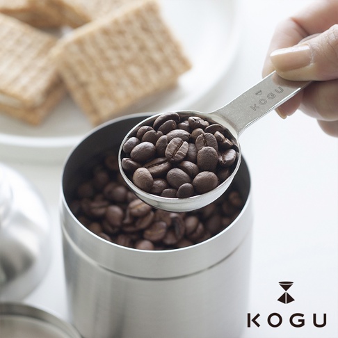 日製18-8不鏽鋼雙頭計量咖啡豆勺，勺頭裝滿淺棕色咖啡豆，上方有KOGU品牌標誌。