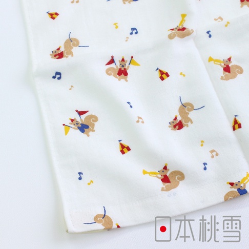 白色紗布毛巾，印有「小小馬戲團」圖案，內容包含穿著紅色衣服、頭戴派對帽、手持黃色旗幟或吹奏黃色喇叭的松鼠，以及紅色與黃色相間的帳篷和音符圖案。