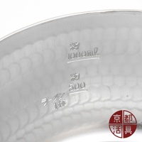 銀色厚板鋁製雪平鍋內側，刻有約 1000ml、約 500ml 及日文「拉麵 1杯」的刻度標示，鍋身有明顯的槌紋，右下角有紅色圓形日文商標。