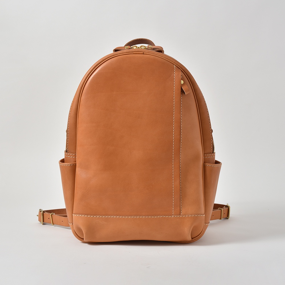 職人手作皮革多功能後背包 R-21，呈現天然棕色皮革質感，設計簡約，配有側邊口袋與拉鍊開口。