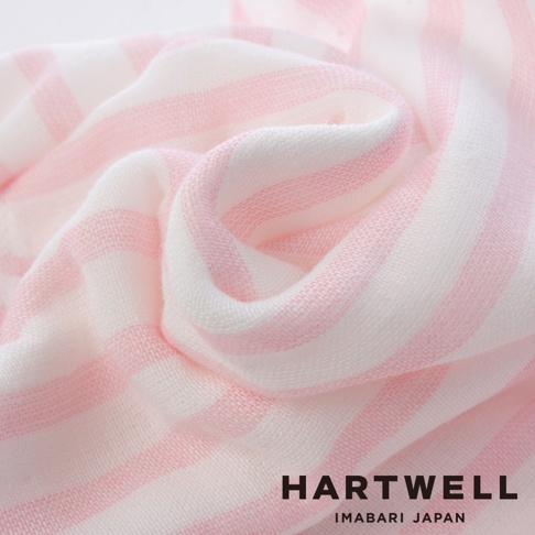 粉色與白色細條紋的紗布材質，質地輕柔，呈現褶皺堆疊的細節，品牌名稱 HARTWELL IMABARI JAPAN 標示於右下角。