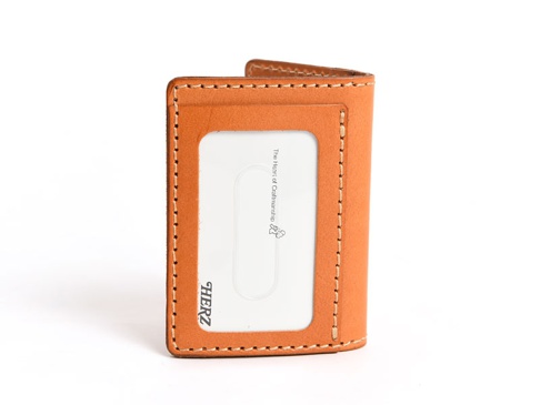 職人手作皮革三面雙折票券收納夾，淺棕色皮革，有一個透明票卡夾層，邊緣縫線整齊，下方印有HERZ品牌標誌。