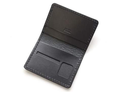 黑色皮革雙折證件夾，手工縫線，內有證件槽與卡槽，展現皮革紋理，簡約設計。