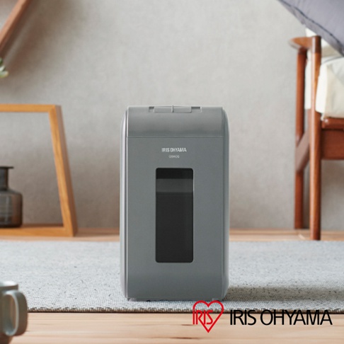 IRIS OHYAMA 灰色極細保密碎紙機，設有透明視窗，擺放在地毯和木質地板上，背景為家居裝飾。
