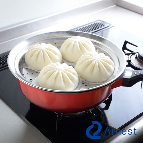 逸品物創不鏽鋼附蓋簡易蒸盤，內有四個白色包子，蒸盤置於紅色鍋中，鍋架於黑色爐上。