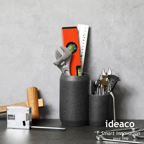 兩個砂岩材質的收納筒，一個較高，一個較低，皆裝有各種工具，包括水平尺、扳手、捲尺和卡尺。