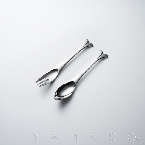 一組以魚形設計的不鏽鋼點心叉匙，叉子有三齒，湯匙形狀飽滿，兩者皆為閃亮的銀色金屬材質，以簡潔的白色背景呈現。