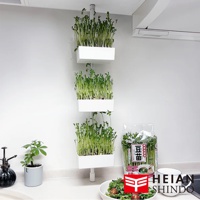 白色直撐式置物架，架上層層疊放著種植綠色豆芽的白色收納盒。