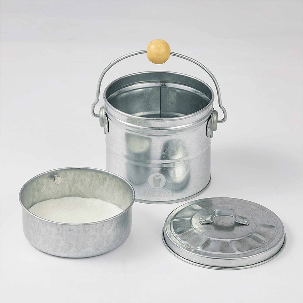 OBAKETSU 品牌手工製鍍鋅鋼製蚊香桶，內附灰盤，旁邊擺放著蚊香桶的蓋子和一個裝有白色粉末的小圓桶。