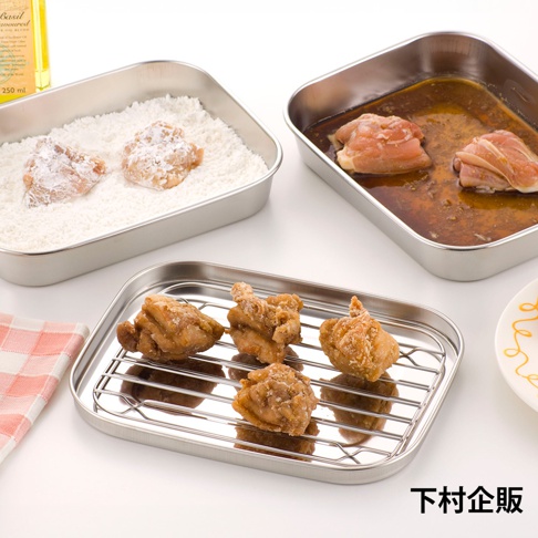 不鏽鋼調理盒內有裹粉雞塊，另一不鏽鋼盒裝有醃漬雞肉，下方另一個較小的長方形不鏽鋼盒上架設網架，網架上擺放著炸好的雞塊。