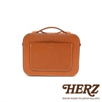 HERZ 職人手作皮革兩用迷你小方包，棕褐色硬皮革材質，正面有壓印品牌標誌與MADE IN JAPAN字樣，車縫線清晰，附手提把，可斜背或側背。