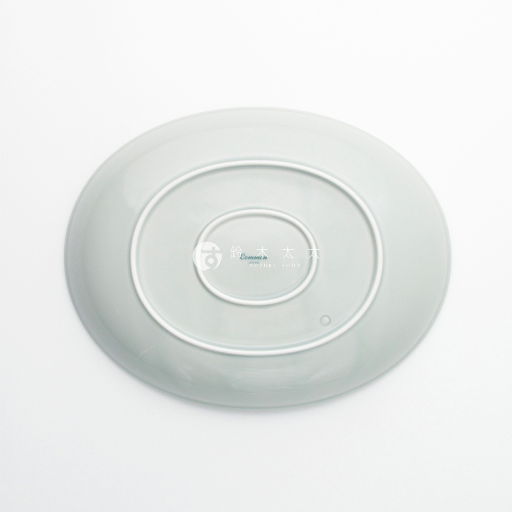 波佐見燒 Common 陶瓷橢圓餐盤，淺綠色，盤底有品牌標誌，光滑表面。