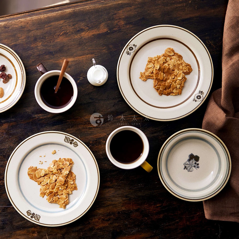 美濃燒葉紋復古溫潤主食深盤，盤面為白色，邊緣有復古棕色線條裝飾，盤身飾有葉紋圖案，其中兩個盤子中盛有杏仁脆片，一旁擺放著咖啡杯與奶盅。