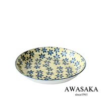 一個帶有藍色小花圖案的淺黃色陶瓷料理盤，盤邊緣有細緻的藍色線條裝飾。