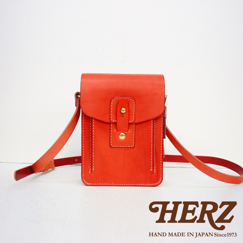 職人手作皮革休閒散步包 CP-52 M，鮮紅色，全皮革製成，帶有黃銅釦環和對比色縫線，風格簡約，附有可調整長度的肩帶。