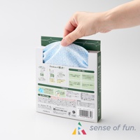 一隻手從印有日文說明與圖示的白色紙盒中抽出藍色、帶有細緻紋理的兩用清潔巾。