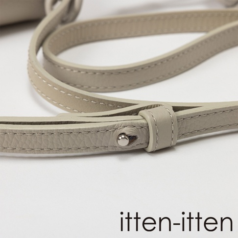 itten-itten 義大利皮革點結吊飾迷你單肩包的細節特寫，展示了皮革材質和縫線。