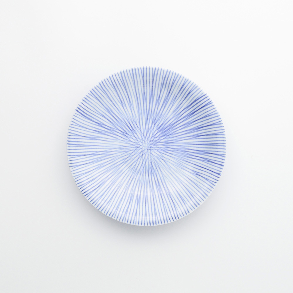 一個白底圓盤，上面繪有細緻的藍色十草紋，紋路從盤子中心向外輻射。