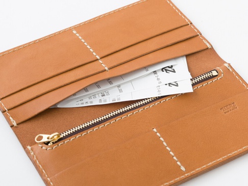 職人手作皮革簡約輕薄扁長夾 (WL-6)，採用天然棕色皮革製成，內有卡槽和拉鍊暗袋，並可見部分收據。