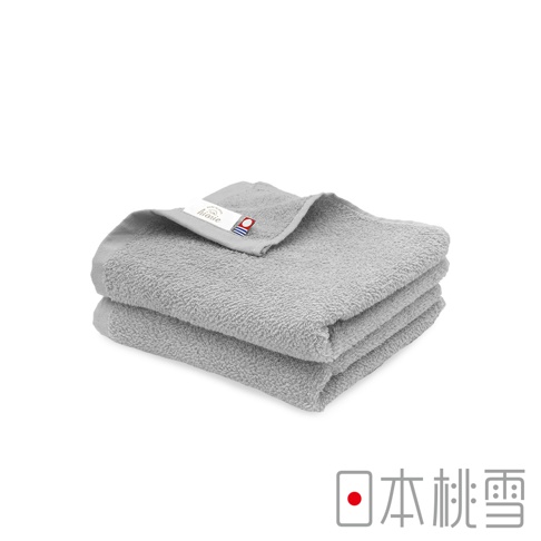 兩件疊放的淺灰色毛巾，材質輕薄，其中一件毛巾上可見品牌標籤。