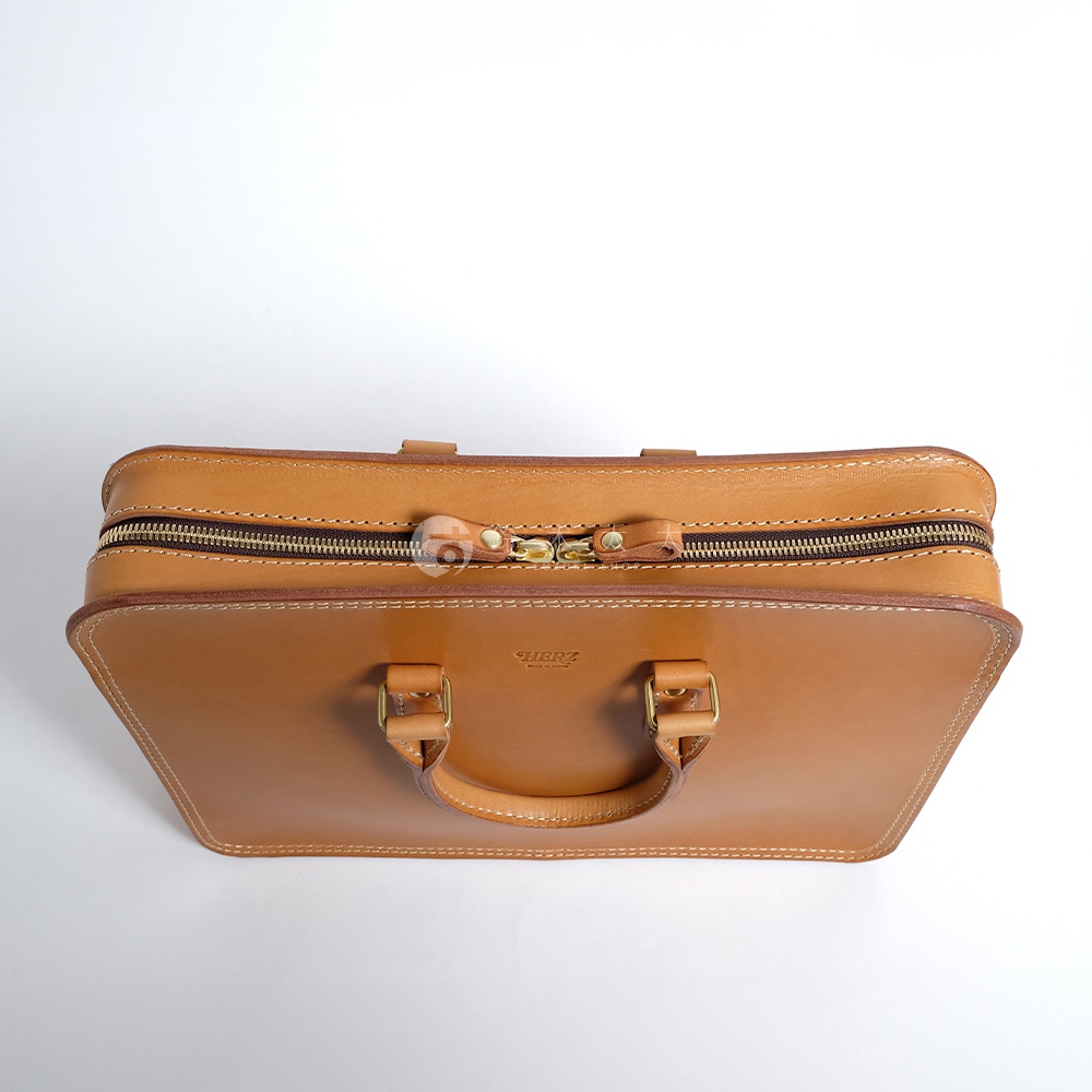 職人手作皮革手提商務公事包，淺棕色，帶有黃銅色拉鍊和釦環，簡潔俐落的方形設計，適合商務人士使用。
